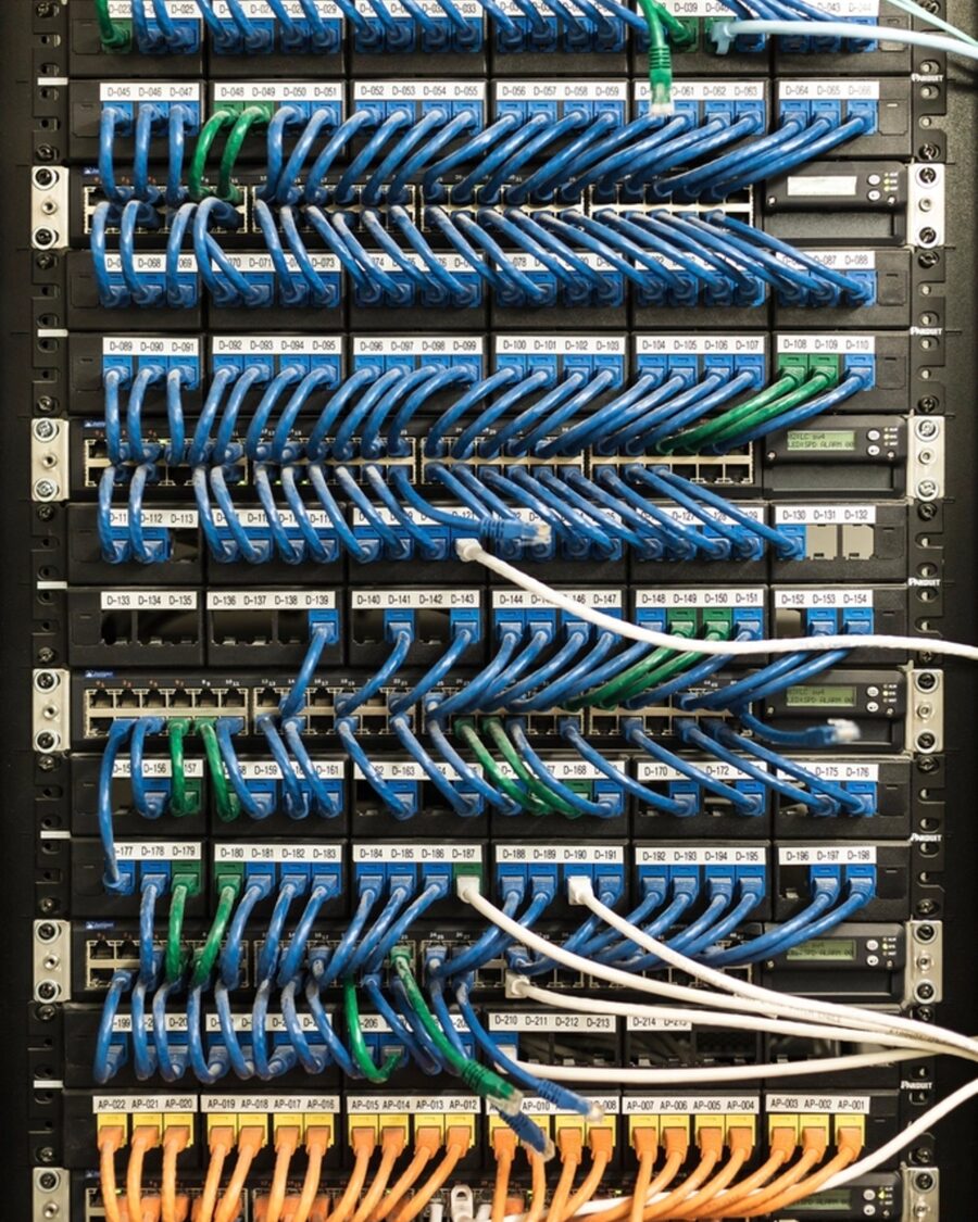 Netzwerkschrank mit sauber rangierten, farblich sortierten Patchkabeln an Patchfeldern.
